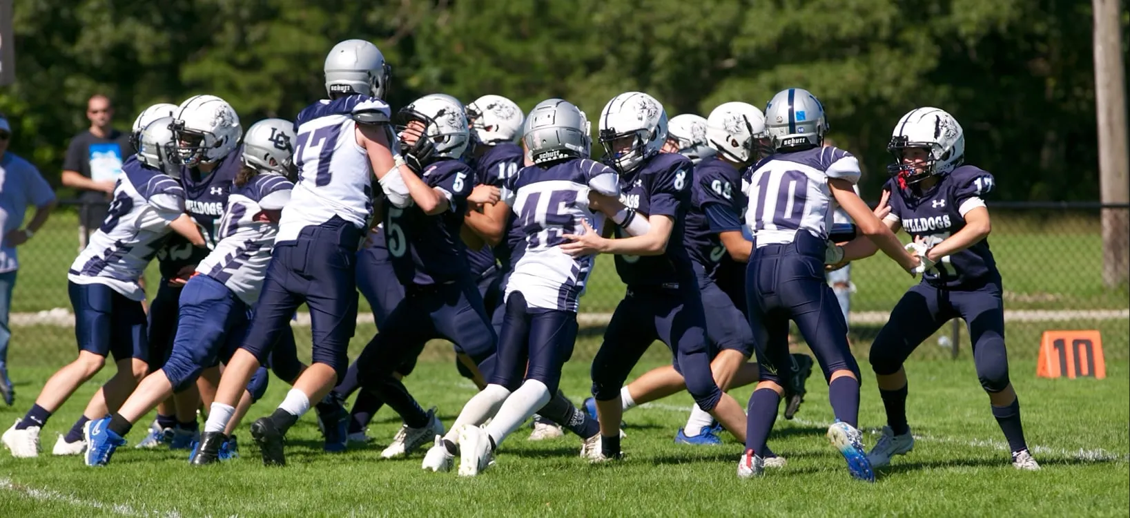Bluefins players in helmets driving forward against an opposing line