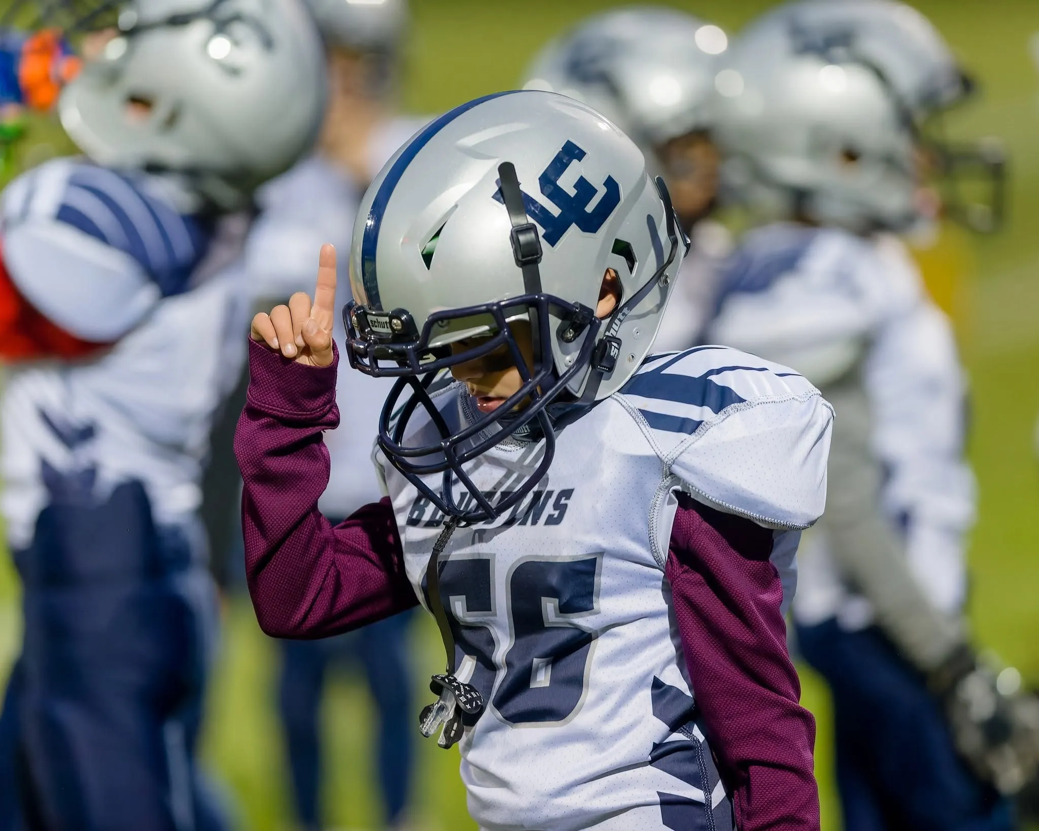 A young Bluefins player in a helmet celebrating after a play